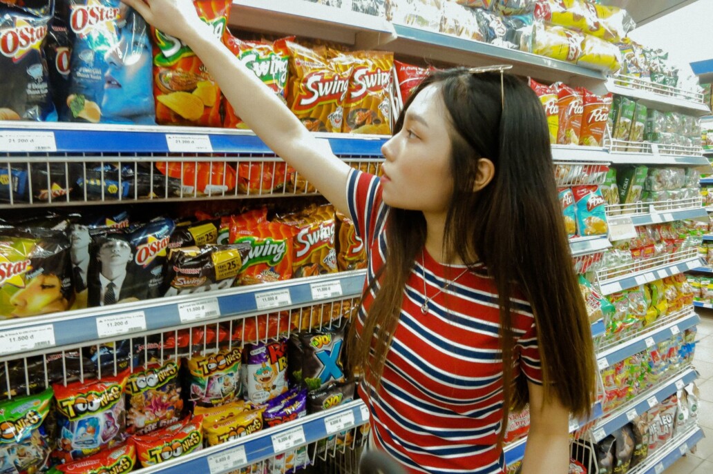 une femme asiatique prend un paquet de chips