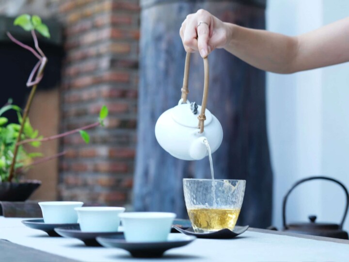 une femme verse une tisane de plantes sauvages